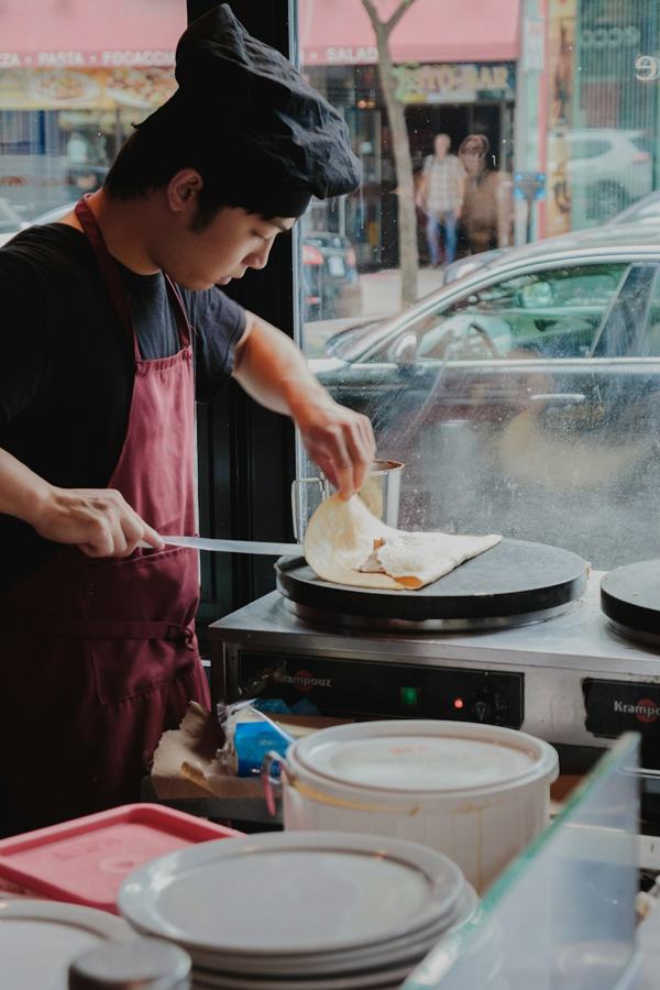 Une crêpière tourne une galette sur le billig